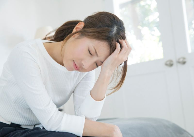 頭をおさえる女性